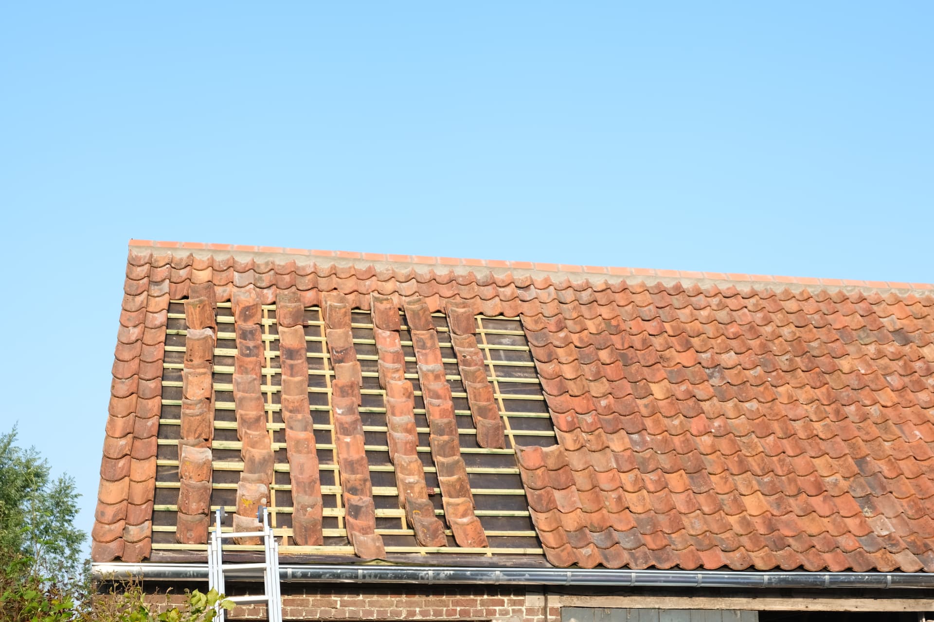 Renovatie van het hoofddak met rode pannen op Aalter — werk in uitvoering
